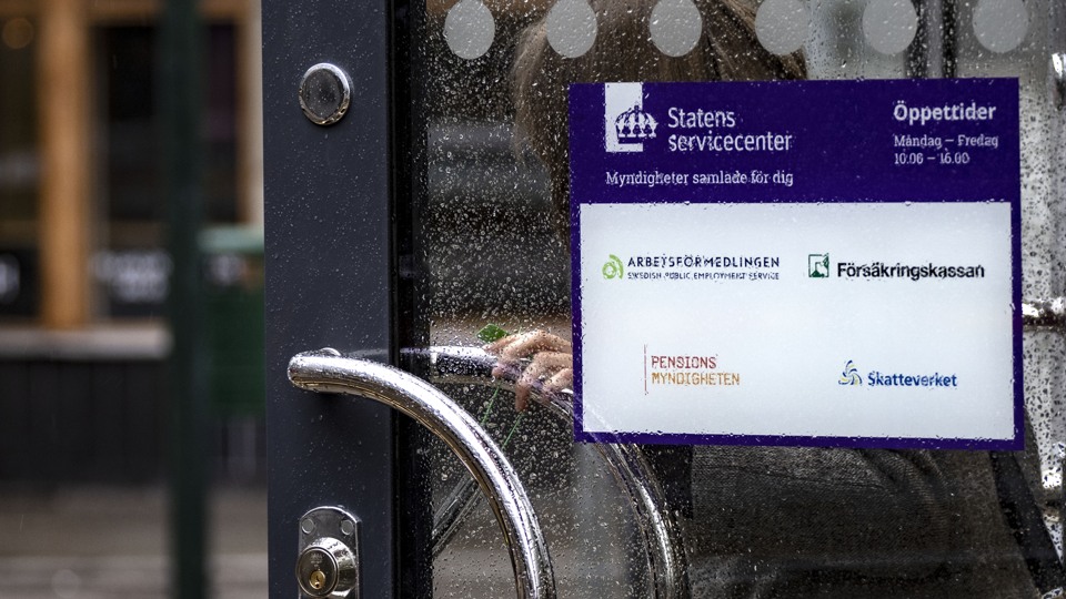 Person öppnar en dörr och går ut från ett servicekontor.